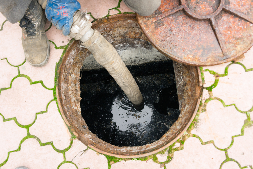 Professional plumber performing rooter service to clear a blocked main sewer line