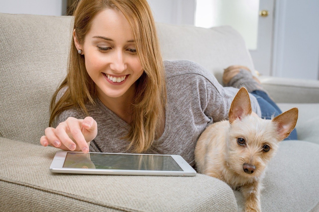 Woman holding a cat and playing in I Pad